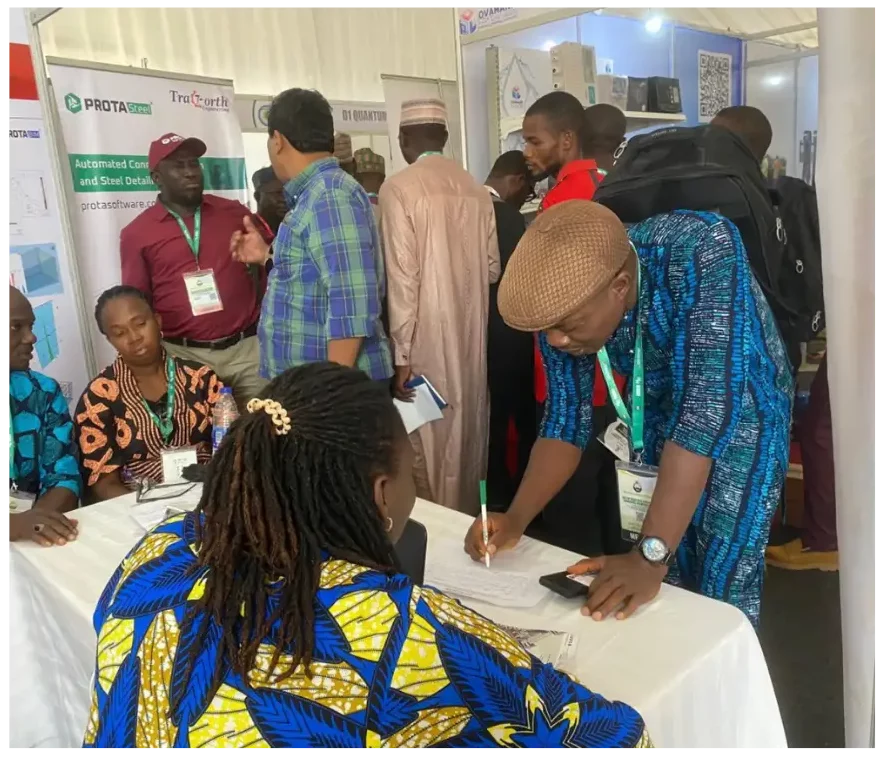 Asistentes interactuando en un stand de exhibición de ProtaStructure en África durante una conferencia.